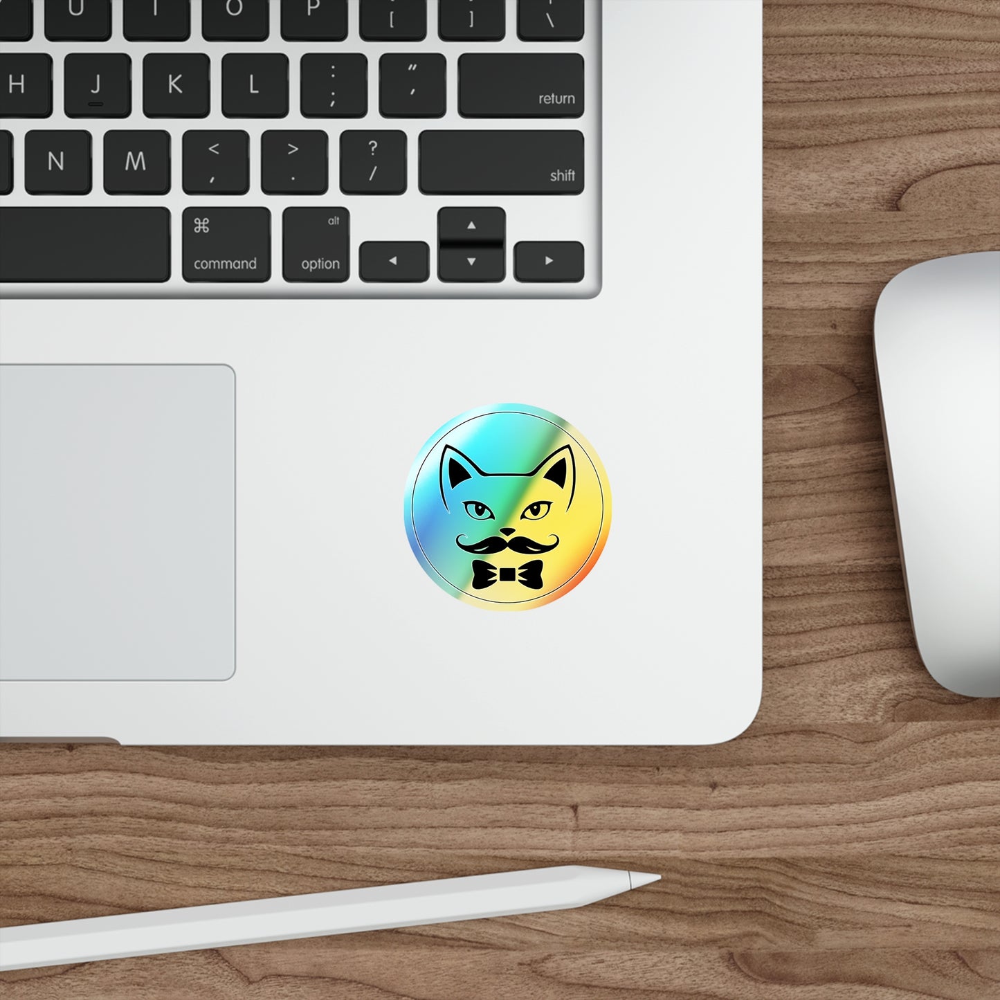 Laptop with a colorful sticker of a cat with a mustache on a wooden desk.