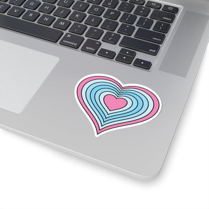 Close-up of the bottom right corner of a silver laptop featuring a 3 inch by 3 inch pride flag heart sticker in a Transmasc flag style applied to the surface.