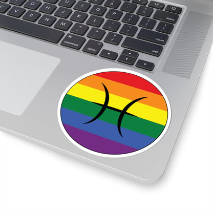 Close-up of the bottom right corner of a silver laptop featuring a 4 inch by 4 inch circular zodiac sticker with a centered Pisces glyph on a Rainbow pride flag style background applied to the surface.