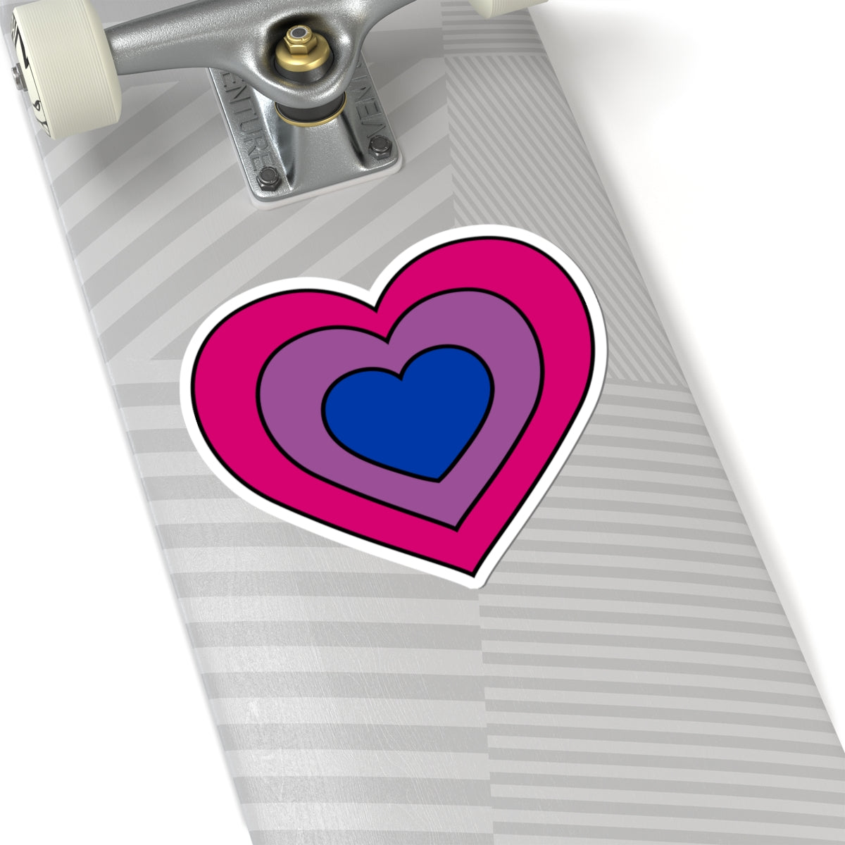 Close-up of the bottom of a silver skateboard featuring a 6 inch by 6 inch pride flag heart sticker in a Bisexual flag style applied to the surface.