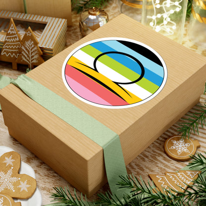 Gift box with a green ribbon on a festive background with cookies and Christmas decorations. Libra Queer pride sticker centered on the box.