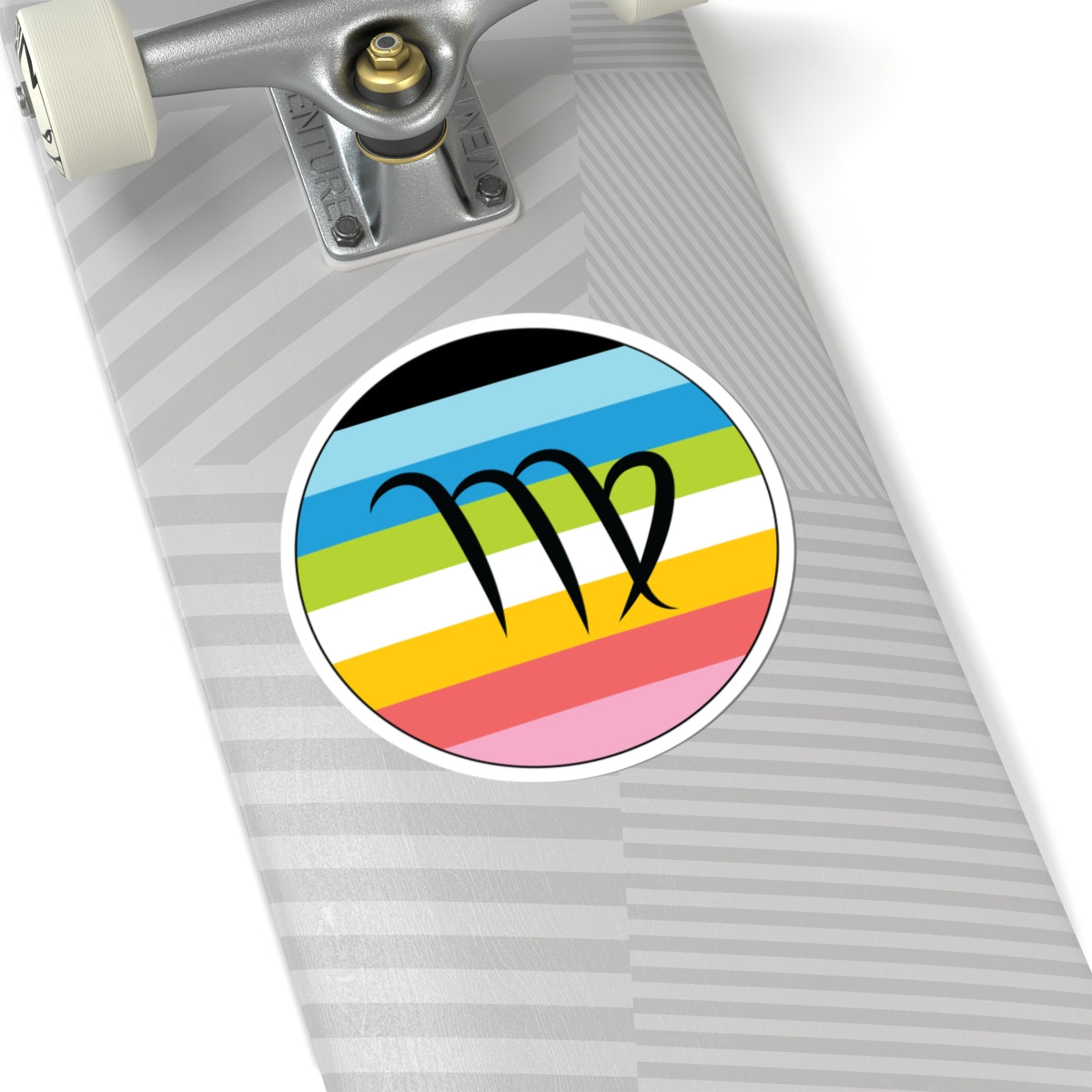 Close-up of the bottom of a silver skateboard featuring a 6 inch by 6 inch circular zodiac sticker with a centered Virgo glyph on a Queer pride flag style background applied to the surface.