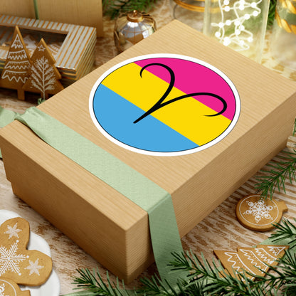 Gift box with a green ribbon on a festive background with cookies and Christmas decorations. Aires Pansexual pride sticker centered on the box.