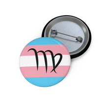 Front and back view of a circular transgender pride flag button featuring the Virgo zodiac symbol in black centered on the front.