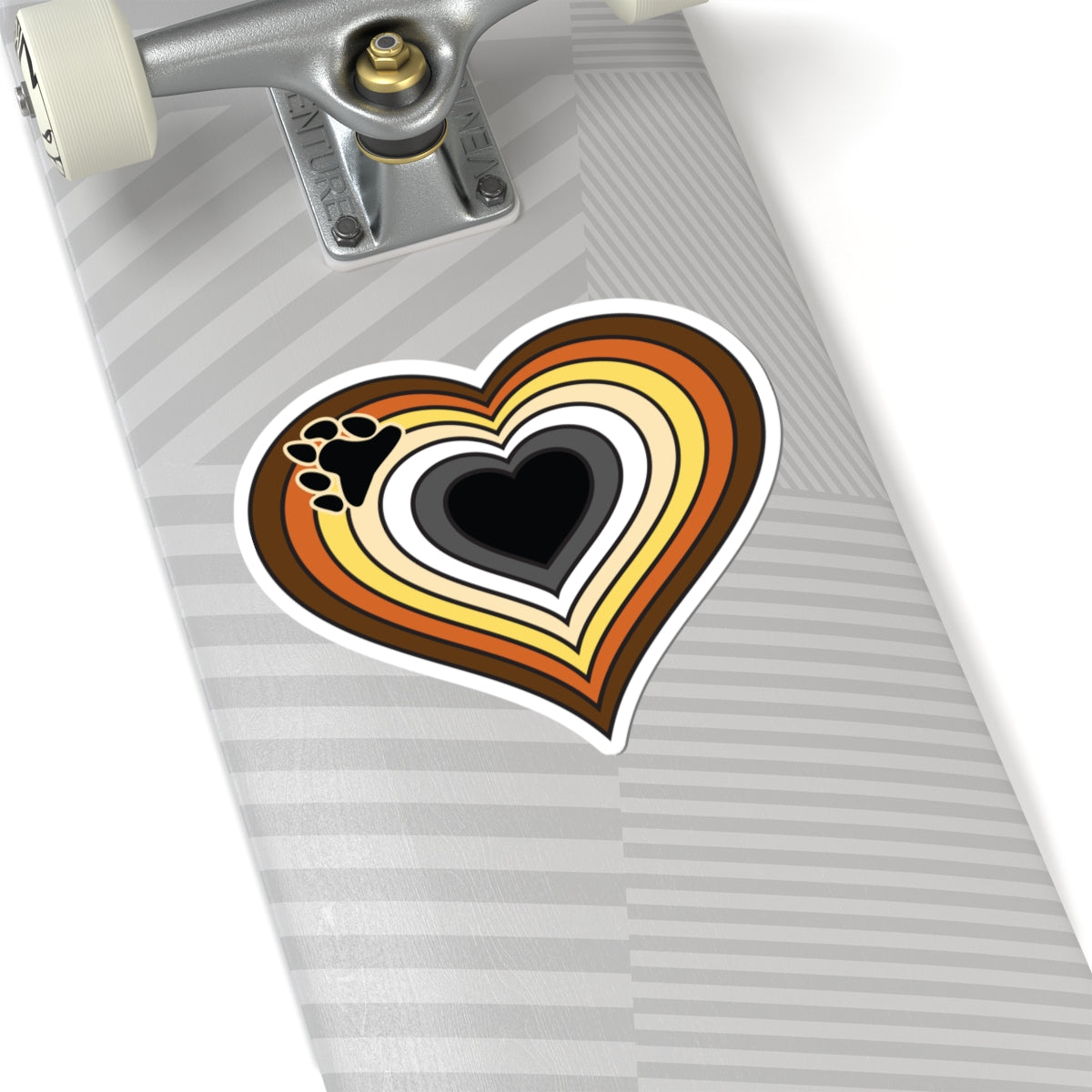 Close-up of the bottom of a silver skateboard featuring a 6 inch by 6 inch pride flag heart sticker in a Bear pride flag style applied to the surface.