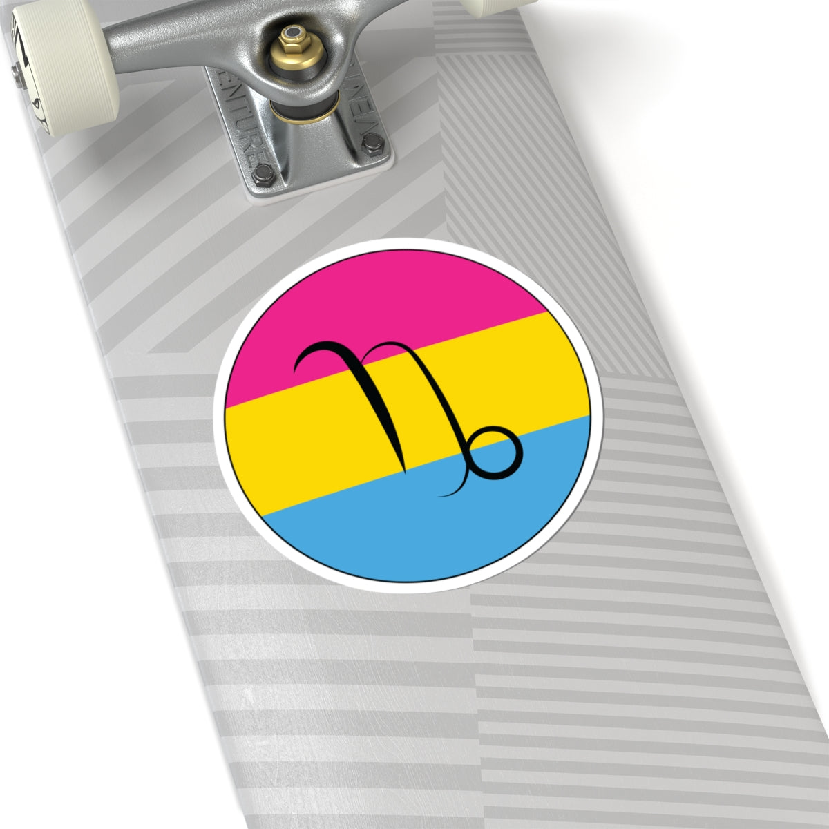 Close-up of the bottom of a silver skateboard featuring a 6 inch by 6 inch circular zodiac sticker with a centered Capricorn glyph on a Pansexual pride flag style background applied to the surface.