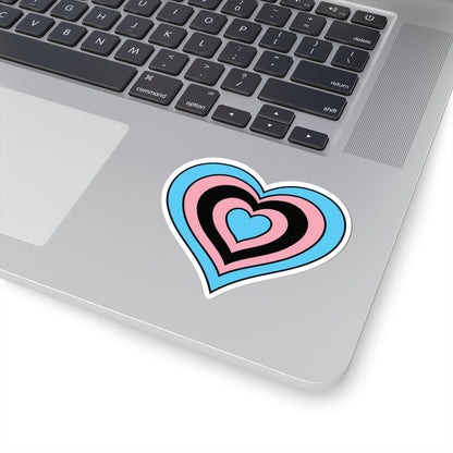 Close-up of the bottom right corner of a silver laptop featuring a 3 inch by 3 inch pride flag heart sticker in a Black Trans flag style applied to the surface.