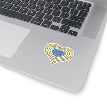 Close-up of the bottom right corner of a silver laptop featuring a 2 inch by 2 inch pride flag heart sticker in a Genderfaun flag style applied to the surface.