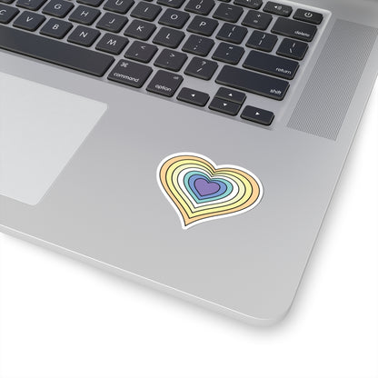 Close-up of the bottom right corner of a silver laptop featuring a 2 inch by 2 inch pride flag heart sticker in a Genderfaun flag style applied to the surface.