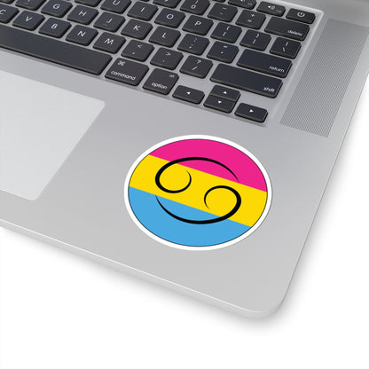 Close-up of the bottom right corner of a silver laptop featuring a 3 inch by 3 inch circular zodiac sticker with a centered Cancer glyph on a Pansexual pride flag style background applied to the surface.