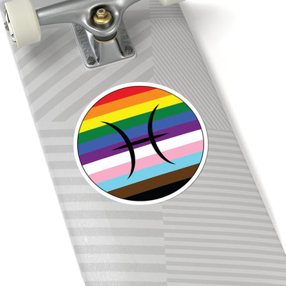 Close-up of the bottom of a silver skateboard featuring a 6 inch by 6 inch circular zodiac sticker with a centered Pisces glyph on a progress pride flag style background applied to the surface.