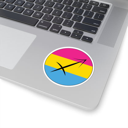 Close-up of the bottom right corner of a silver laptop featuring a 3 inch by 3 inch circular zodiac sticker with a centered Sagittarius glyph on a Pansexual pride flag style background applied to the surface.