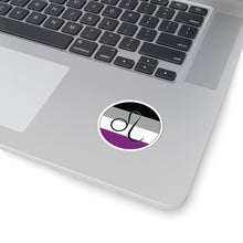 Close-up of the bottom right corner of a silver laptop featuring a 2 inch by 2 inch circular zodiac sticker with a centered Leo glyph on an Asexual pride flag style background applied to the surface.