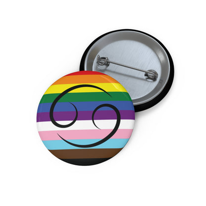 Front and back view of a circular progress pride flag button featuring the Cancer zodiac symbol in black centered on the front.
