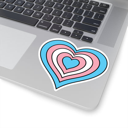 Close-up of the bottom right corner of a silver laptop featuring a 4 inch by 4 inch pride flag heart sticker in a Transgender flag style applied to the surface.