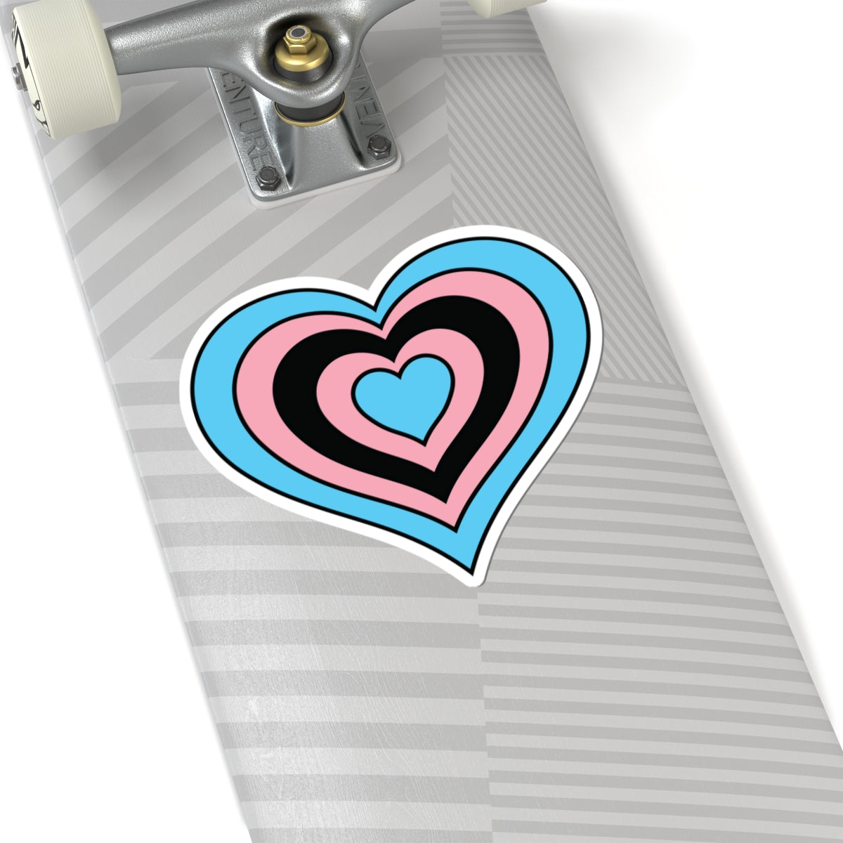 Close-up of the bottom of a silver skateboard featuring a 6 inch by 6 inch pride flag heart sticker in a Black Trans flag style applied to the surface.