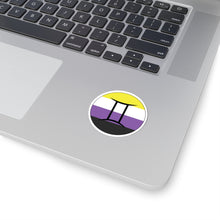 Close-up of the bottom right corner of a silver laptop featuring a 2 inch by 2 inch circular zodiac sticker with a centered Gemini glyph on a Nonbinary pride flag style background applied to the surface.