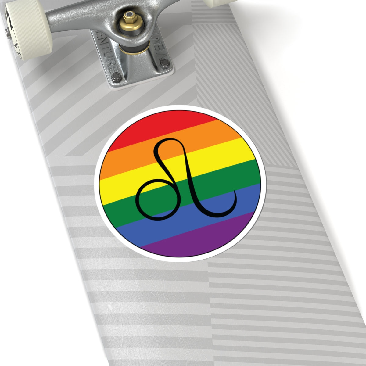 Close-up of the bottom of a silver skateboard featuring a 6 inch by 6 inch circular zodiac sticker with a centered Leo glyph on a Rainbow pride flag style background applied to the surface.