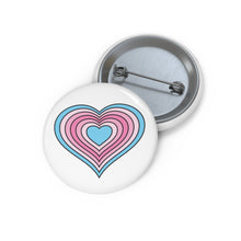 Front and back view of a white circular button with a heart-shaped transfeminine pride flag image. The button is shown on a white background.