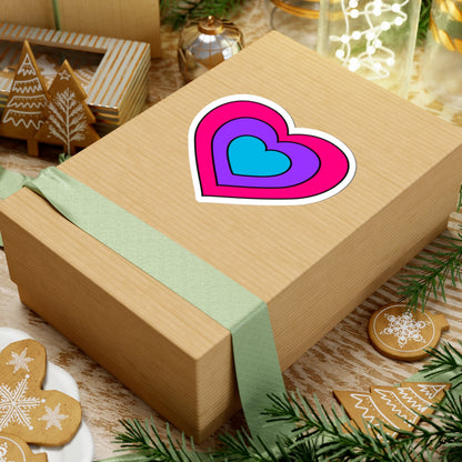 Gift box with a green ribbon on a festive background with cookies and Christmas decorations. Heart-shaped Androgyne pride sticker centered on the box.