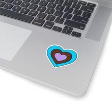Close-up of the bottom right corner of a silver laptop featuring a 2 inch by 2 inch pride flag heart sticker in an Androsexual flag style applied to the surface.