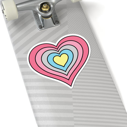 Close-up of the bottom of a silver skateboard featuring a 6 inch by 6 inch pride flag heart sticker in a Genderflux flag style applied to the surface.