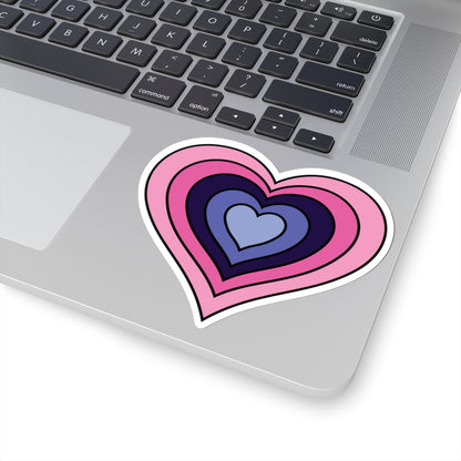 Close-up of the bottom right corner of a silver laptop featuring a 4 inch by 4 inch pride flag heart sticker in an Omnigender flag style applied to the surface.