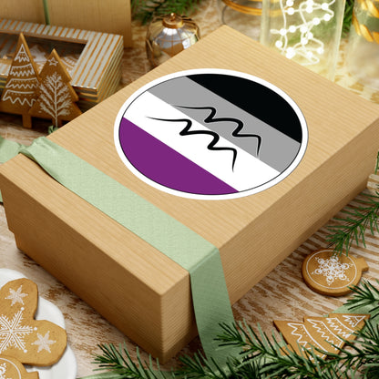 Gift box with a green ribbon on a festive background with cookies and Christmas decorations. Aquarius Asexual pride sticker centered on the box.
