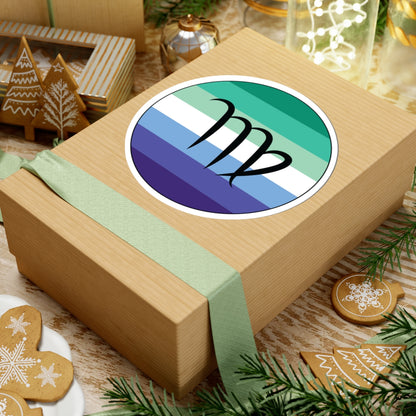 Gift box with a green ribbon on a festive background with cookies and Christmas decorations. Virgo Gay Men pride sticker centered on the box.