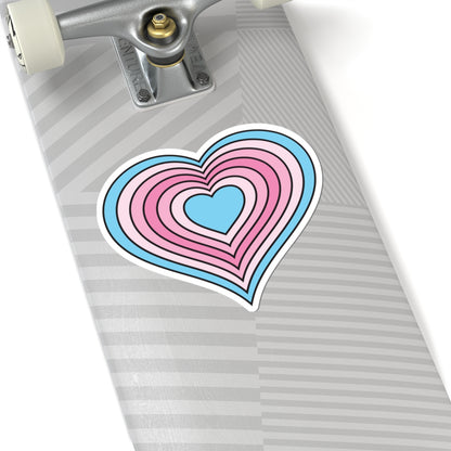 Close-up of the bottom of a silver skateboard featuring a 6 inch by 6 inch pride flag heart sticker in a Transfem flag style applied to the surface.