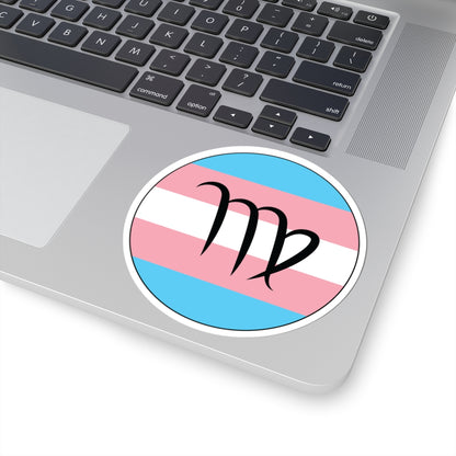 Close-up of the bottom right corner of a silver laptop featuring a 4 inch by 4 inch circular zodiac sticker with a centered Virgo glyph on a Transgender pride flag style background applied to the surface.