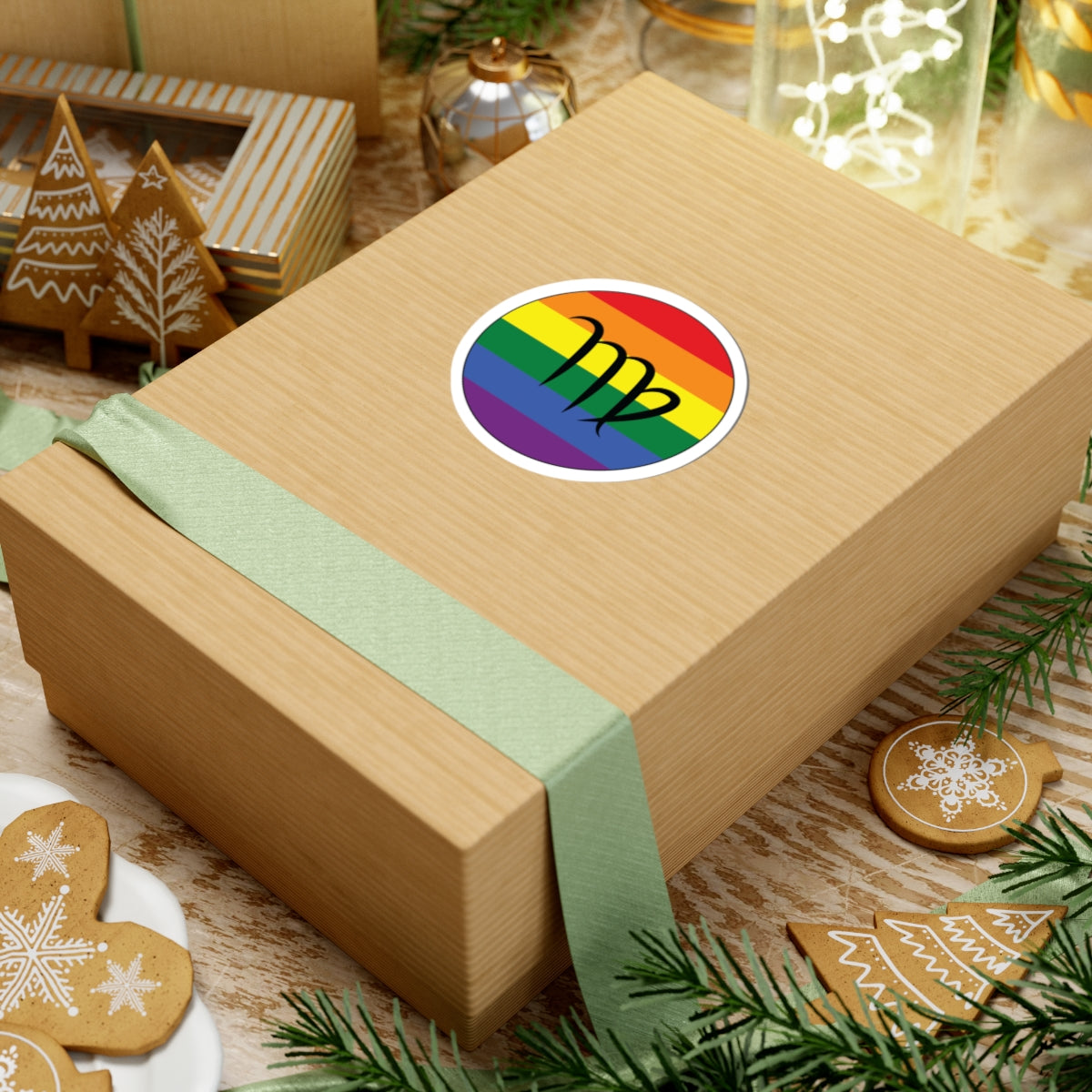 Gift box with a green ribbon on a festive background with cookies and Christmas decorations. Virgo Rainbow pride sticker centered on the box.