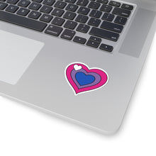 Close-up of the bottom right corner of a silver laptop featuring a 2 inch by 2 inch pride flag heart sticker in a Biromantic flag style applied to the surface.