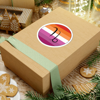 Gift box with a green ribbon on a festive background with cookies and Christmas decorations. Capricorn Lesbian pride sticker centered on the box.
