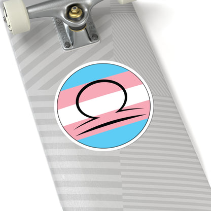 Close-up of the bottom of a silver skateboard featuring a 6 inch by 6 inch circular zodiac sticker with a centered Libra glyph on a Transgender pride flag style background applied to the surface.