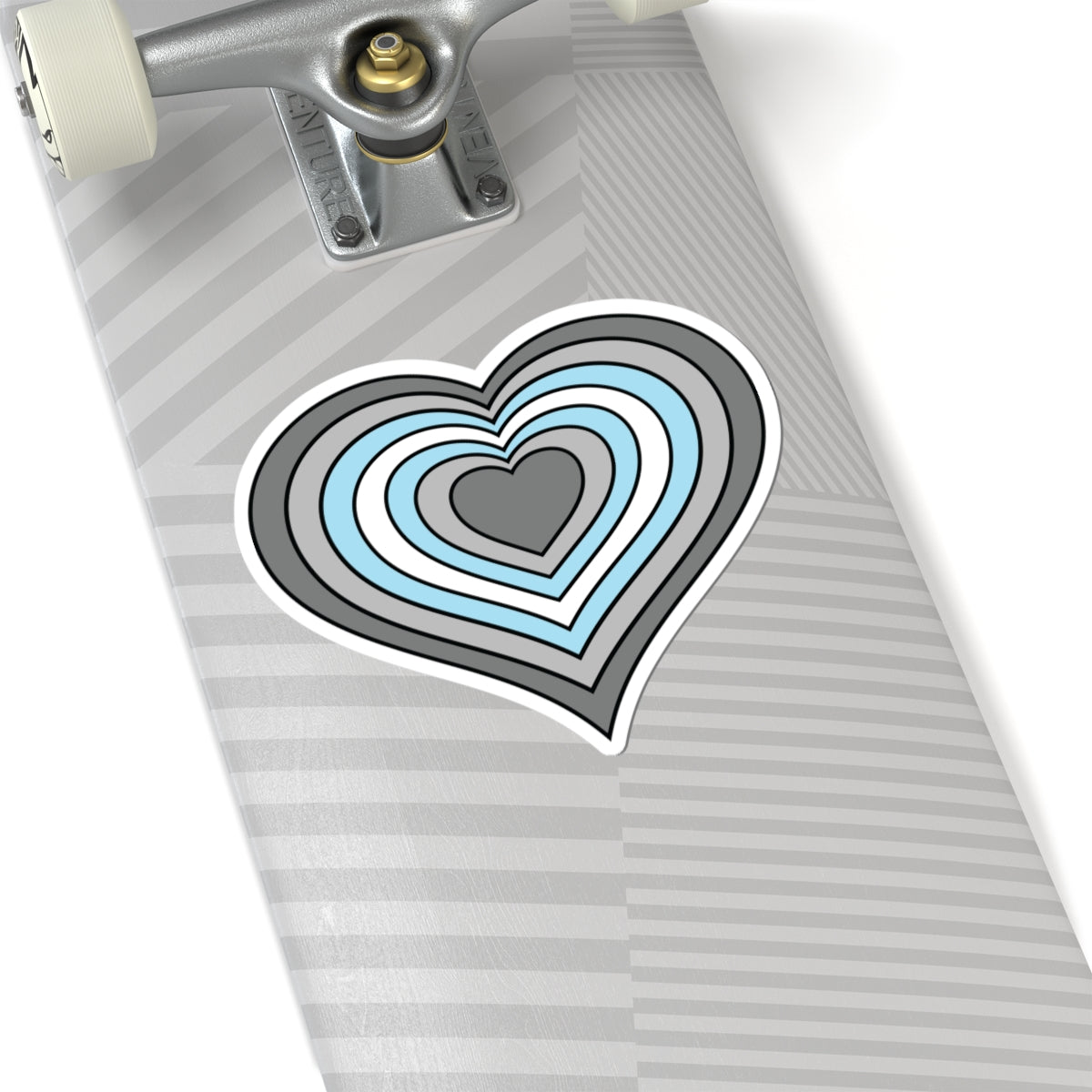Close-up of the bottom of a silver skateboard featuring a 6 inch by 6 inch pride flag heart sticker in a Demiboy flag style applied to the surface.