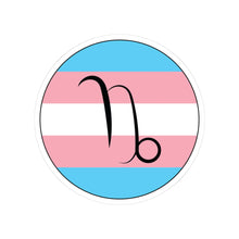 Circular transgender pride flag zodiac sticker with a thin black outline and white sticker border, featuring a centered black Capricorn zodiac glyph. The sticker is shown on a white background.