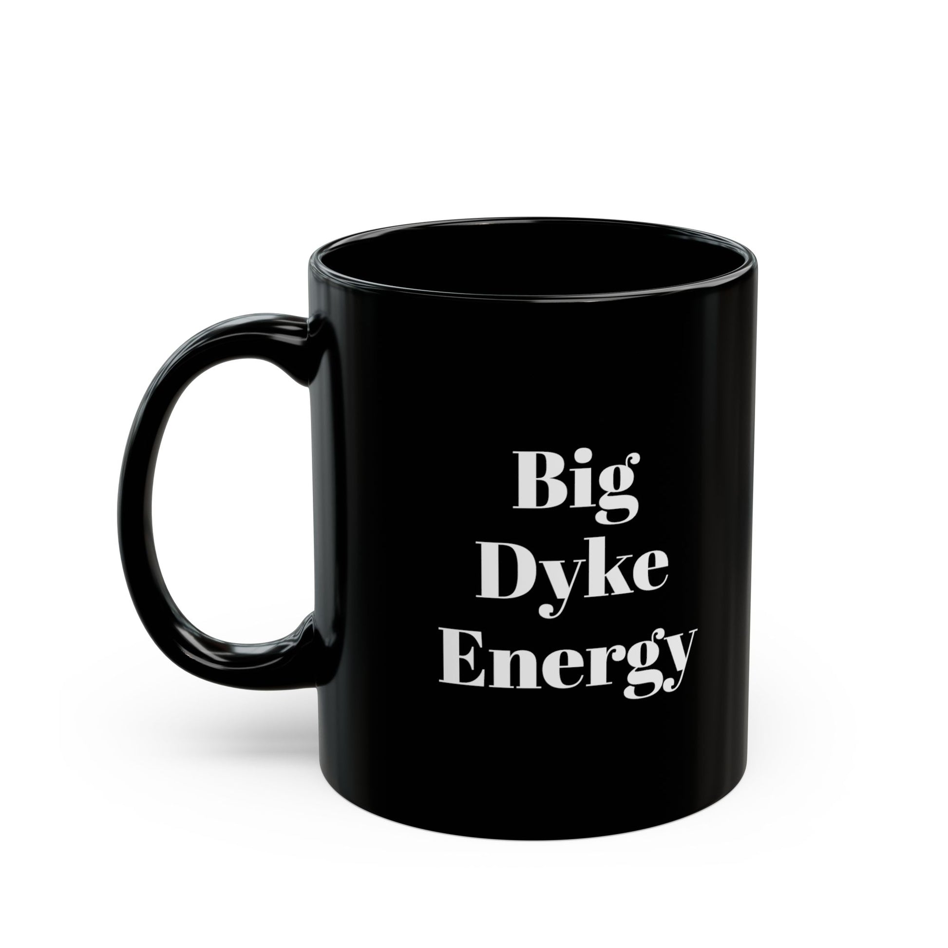 A black mug with the words "Big Dyke Energy" printed in white letters on the side facing outward if the mug is held by the handle in the right hand. The image of the mug is shown on a white background.