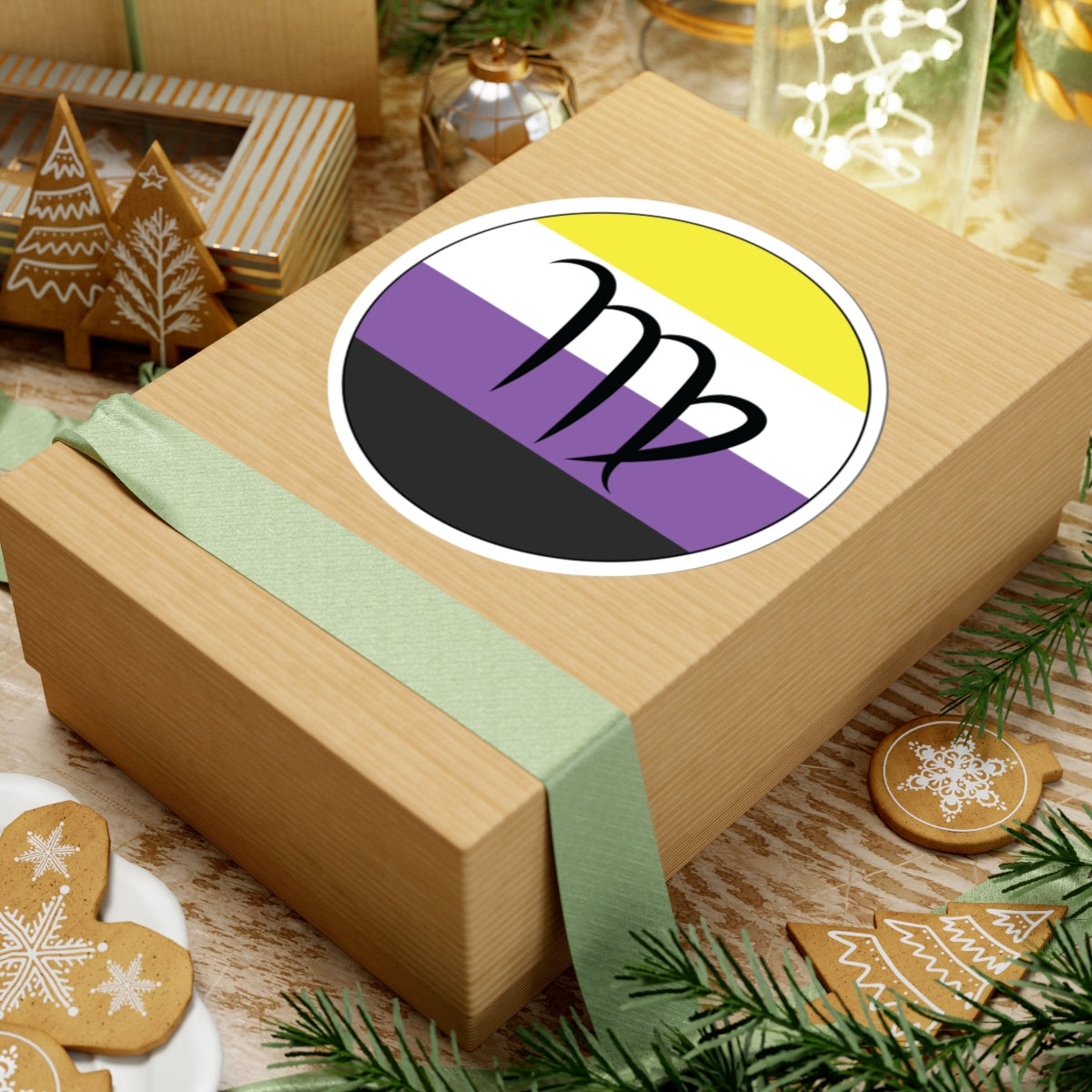 Gift box with a green ribbon on a festive background with cookies and Christmas decorations. Virgo Nonbinary pride sticker centered on the box.