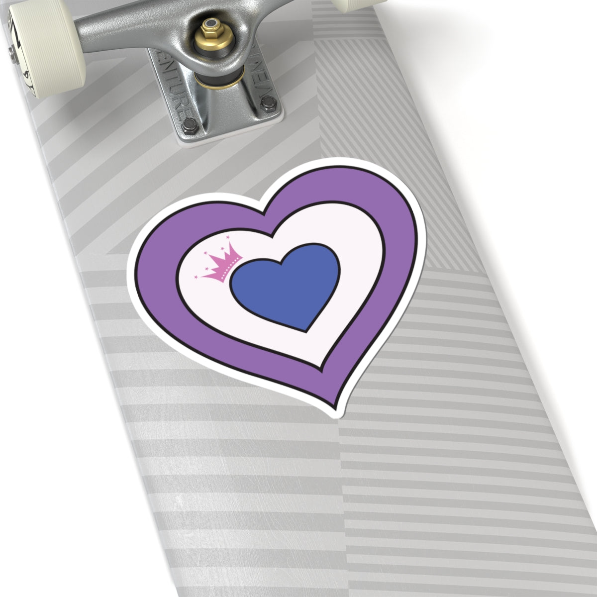 Close-up of the bottom of a silver skateboard featuring a 6 inch by 6 inch pride flag heart sticker in a Drag pride flag style applied to the surface.