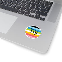 Close-up of the bottom right corner of a silver laptop featuring a 2 inch by 2 inch circular zodiac sticker with a centered Virgo glyph on a Queer pride flag style background applied to the surface.