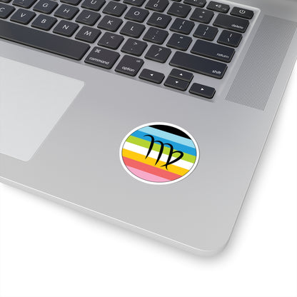 Close-up of the bottom right corner of a silver laptop featuring a 2 inch by 2 inch circular zodiac sticker with a centered Virgo glyph on a Queer pride flag style background applied to the surface.