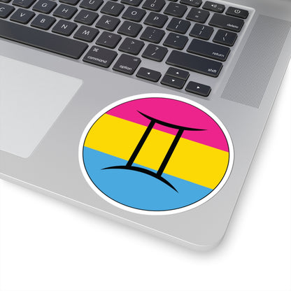 Close-up of the bottom right corner of a silver laptop featuring a 4 inch by 4 inch circular zodiac sticker with a centered Gemini glyph on a Pansexual pride flag style background applied to the surface.