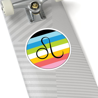 Close-up of the bottom of a silver skateboard featuring a 6 inch by 6 inch circular zodiac sticker with a centered Leo glyph on a Queer pride flag style background applied to the surface.