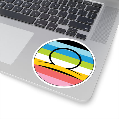 Close-up of the bottom right corner of a silver laptop featuring a 4 inch by 4 inch circular zodiac sticker with a centered Libra glyph on a Queer pride flag style background applied to the surface.