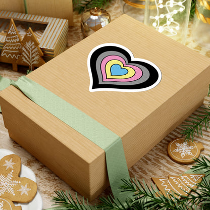 Gift box with a green ribbon on a festive background with cookies and Christmas decorations. Heart-shaped Polygender pride sticker centered on the box.