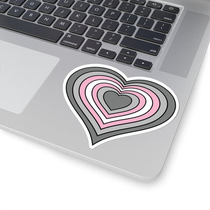 Close-up of the bottom right corner of a silver laptop featuring a 4 inch by 4 inch pride flag heart sticker in a Demigirl flag style applied to the surface.