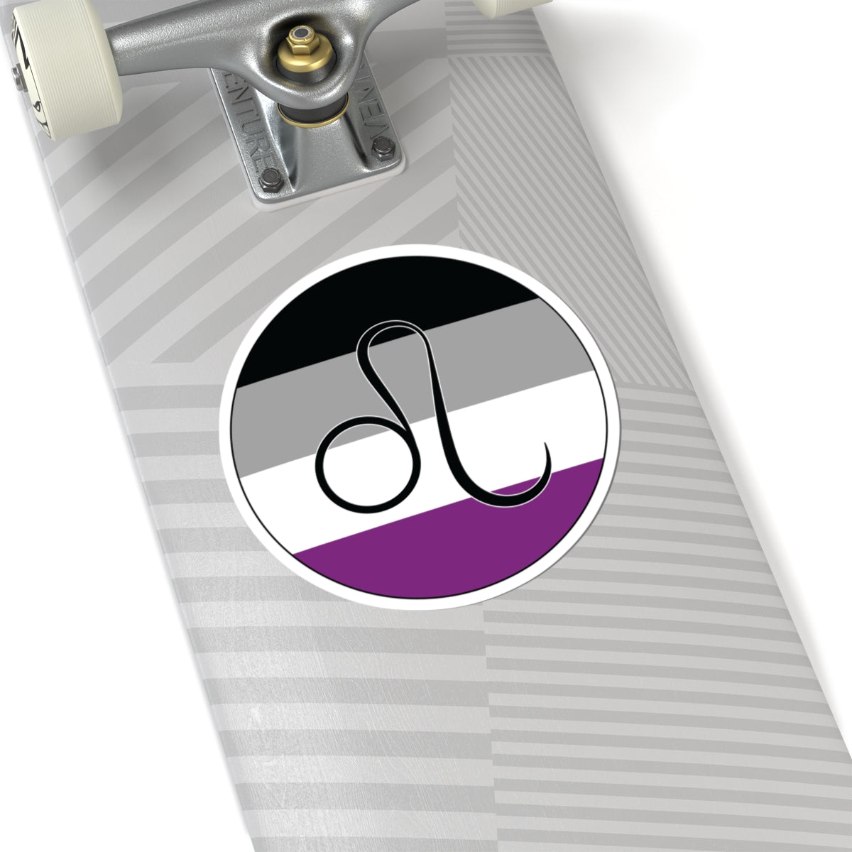 Close-up of the bottom of a silver skateboard featuring a 6 inch by 6 inch circular zodiac sticker with a centered Leo glyph on an Asexual pride flag style background applied to the surface.