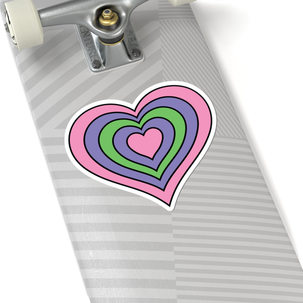 Close-up of the bottom of a silver skateboard featuring a 6 inch by 6 inch pride flag heart sticker in a Trigender flag style applied to the surface.