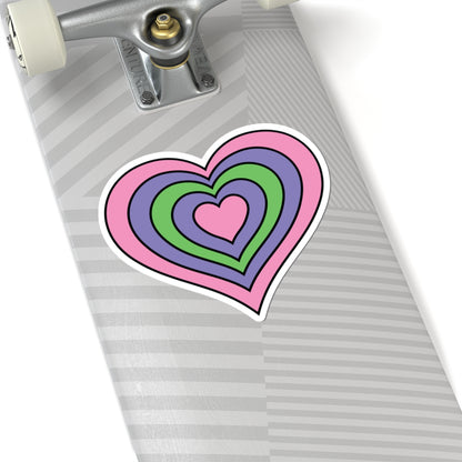 Close-up of the bottom of a silver skateboard featuring a 6 inch by 6 inch pride flag heart sticker in a Trigender flag style applied to the surface.
